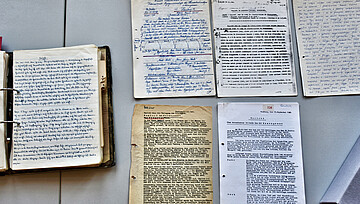 Handgeschriebene Häftlingsberichte liegen auf einem Tisch im Archiv der KZ-Gedenkstätte Neuengamme
