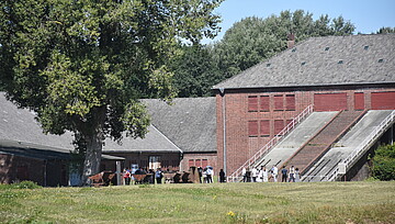 Besucher der Gedenkstätte vor dem historischen Klinkerwerk