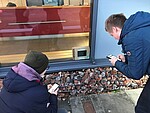 Zwei Personen vor einem kleinen Bildschirm mit Bildinformationen in der Gedenkstätte