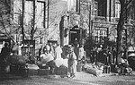 Schwarzweißfoto von Menschen, die unter Bewachung des Reserve-Polizeibataillons 101 am Logengebäude ankommen