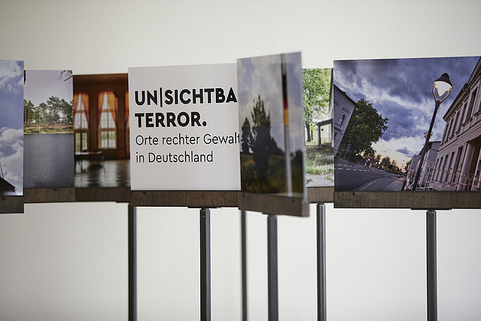 Fotos auf Stäben der Ausstellung Unsichtbarer Terror
