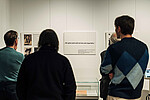 Ausstellung „Ganz Hamburg ist voll von diesen Abtransporten“ mit drei Personen, die vor einer Ausstellungstafel mit Fotos stehen
