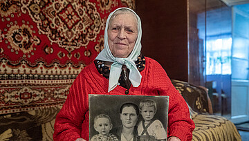 Pelаheya Novikova hält ein schwarzweiß Foto ihrer Familie