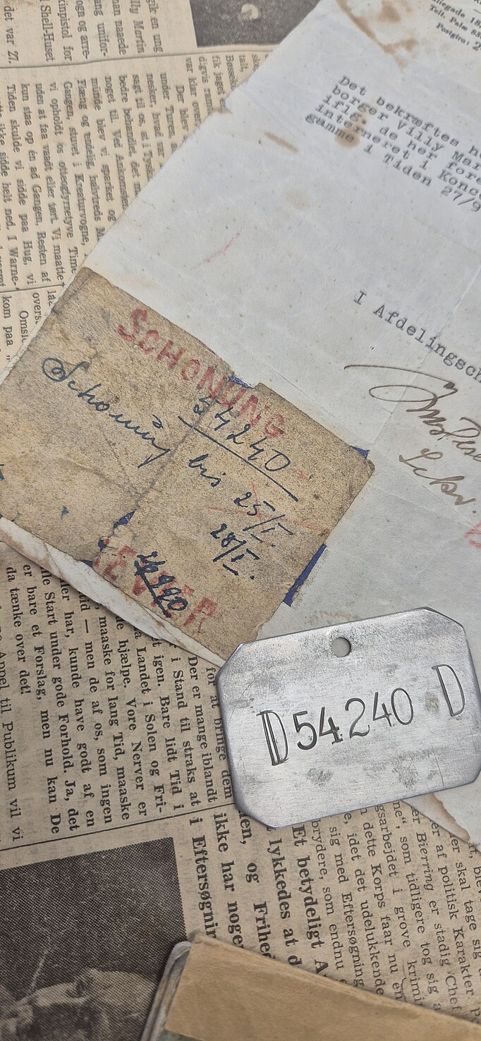 Dokumente von Evensen, darunter eine Blechmarke und ein Schriftstück aus dem KZ