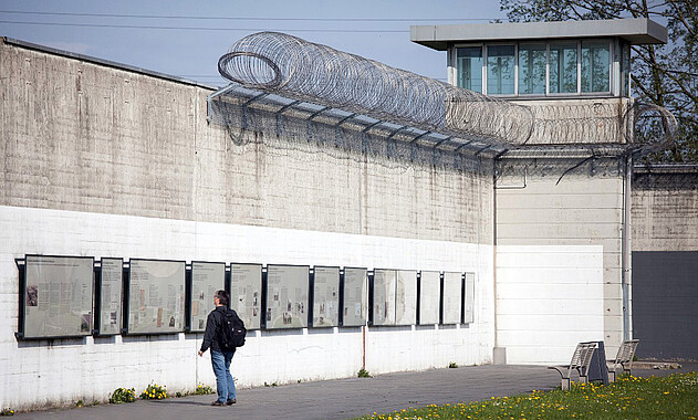 Gefängnisse und Gedenkstätten Foto der Freiluft-Ausstellung an den Resten der ehemaligen Gefängnismauer. Foto: DEKT - Tristan Vankann, 2013.