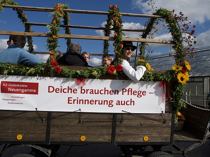 Erntedankwagen der Gedenkstätte mit Banner "Deiche brauchen Pflege - Erinnerung auch"