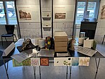 Ein Tisch in der Mitte des Ausstellungsraumes, voll mit Modellen und Bastelsachen