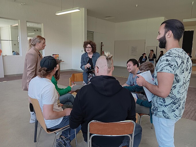 Personen in einem Schulkreis, im Zentrum die Seminarleiterin