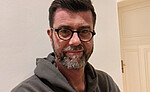 Portrait von Jaromir Balzar. Er trägt eine Brille und einen Kapuzenpullover.