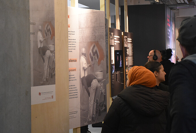 Blick in die Ausstellung "Rechte Gewalt in Hamburg nach 1945" im St. Pauli Museum. Verschiedene Personen, zum Teil mit Kopfhörer, sehen sich Tafeln mit Bildern und Texten an.
